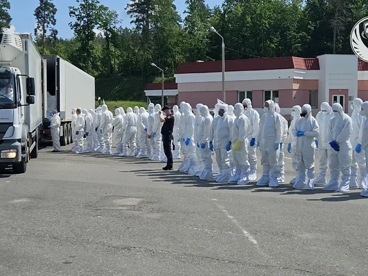 Personnel en combinaisons blanches lors de la réception de dépouilles de personnes tuées.