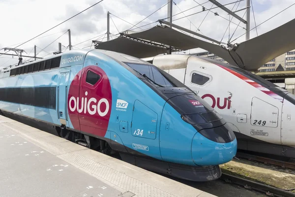Un train OUIGO de la SNCF et un train blanc à quai, illustrant la concurrence sur le marché du TGV.
