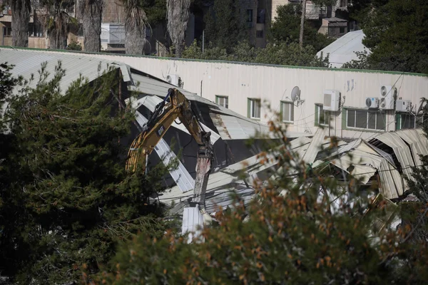Démolition d'un bâtiment de l'UNRWA à Jérusalem-Est par une excavatrice.