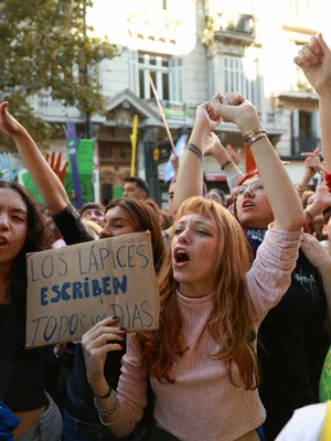 Manifestants avec une pancarte 'Les crayons écrivent tous les jours' lors d'une protestation pour l'université publique.