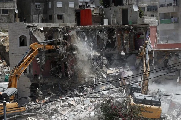 Démolition d'un immeuble à Jérusalem-Est par des engins de chantier israéliens.