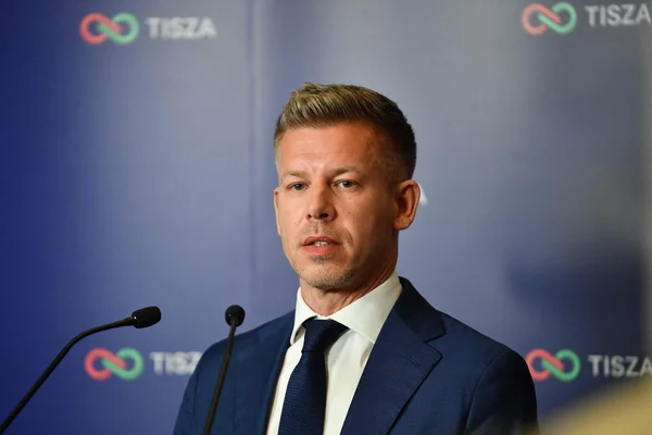 Péter Magyar s'exprimant lors d'un événement devant le logo du parti TISZA.