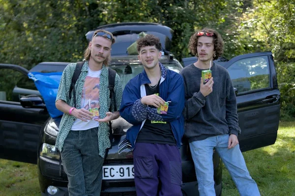 Participants de l'Euro Mulet 2025 posant devant une Citroën noire, chacun avec une brique de jus.