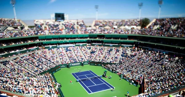 Vue aérienne du stade d'Indian Wells avec un match en cours et une foule nombreuse.