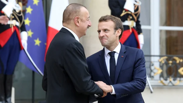 Poignée de main entre deux hommes en costume, lors d’une rencontre officielle.