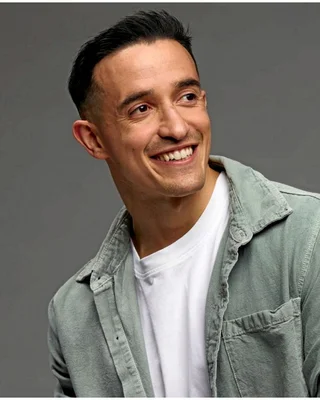 Portrait souriant de Tibo InShape en extérieur.