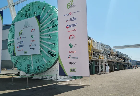 Le tunnelier du projet Lyon-Turin exposé avec les logos des entreprises partenaires.