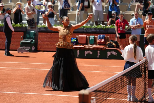 Naomi Osaka fait une entrée remarquée sur le court Suzanne-Lenglen, vêtue d'une tenue dorée et d'une jupe noire volumineuse.
