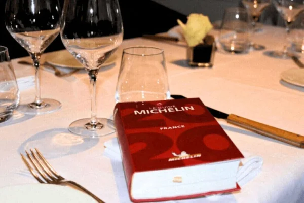 Table dressée avec le Guide Michelin 2026 France en évidence.