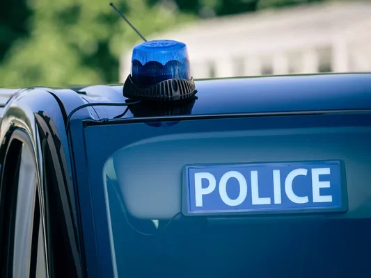 Véhicule de police avec gyrophare et inscription 'POLICE'.