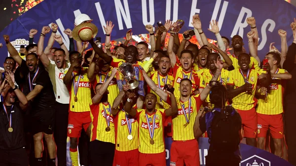 Les joueurs du RC Lens fêtent leur victoire avec le trophée de la Coupe de France.