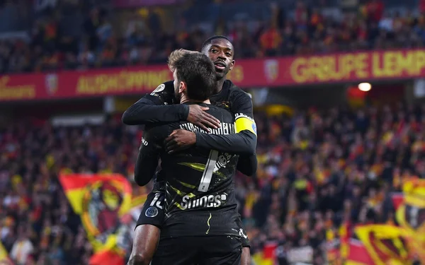 Ousmane Dembélé et un coéquipier du PSG s'enlacent après le match.