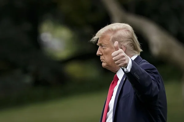 Donald Trump exprimant son approbation avec un pouce levé.