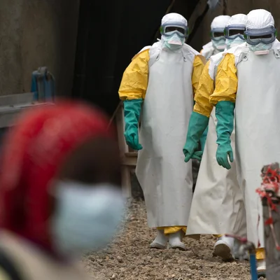 Des agents de santé en tenue de protection se déplacent sur un site d'intervention contre Ebola en RDC.