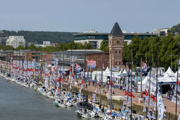 Les voiliers de la Solitaire du Figaro amarrés dans le port de Rouen, avec la tour de l'horloge en arrière-plan.