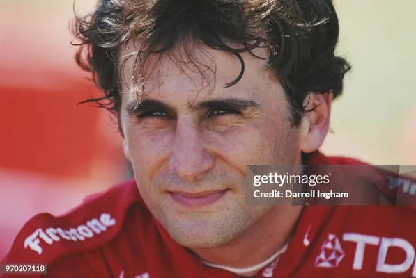 Alex Zanardi vêtu d'une combinaison de course rouge avec les logos de ses sponsors.