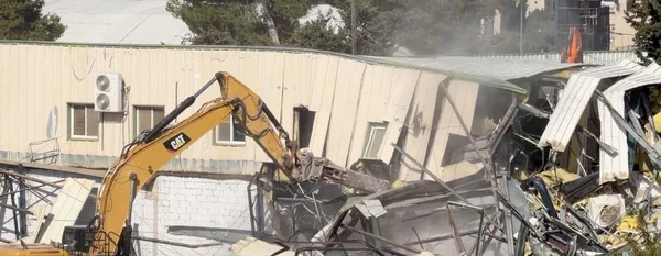 Démolition du siège de l'UNRWA à Jérusalem-Est par une excavatrice Caterpillar.