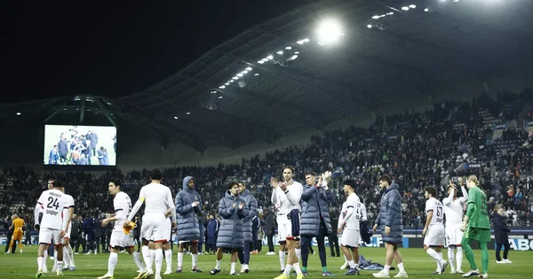 Les joueurs du PSG saluent le public après un match au stade, dans une ambiance de grande compétition.