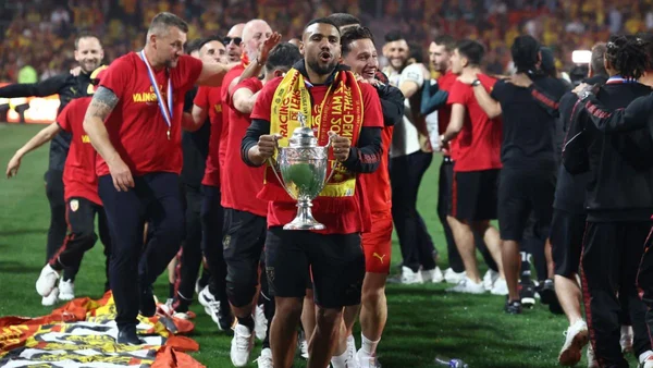 Un joueur lensois soulève le trophée de la Coupe de France après la victoire.