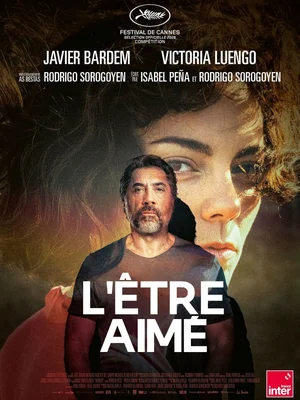 Javier Bardem interviewé avec l'affiche de 'L'Être Aimé' en arrière-plan.