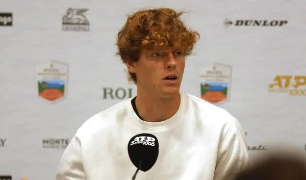 Jannik Sinner lors d'une conférence de presse, s'exprimant au micro.