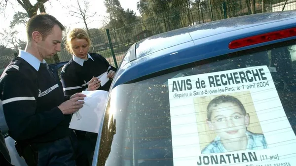 Des gendarmes français avec un véhicule portant l'avis de recherche de Jonathan Coulom.