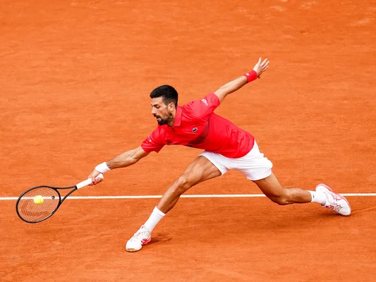 Un joueur en action sur la terre battue de Roland-Garros.