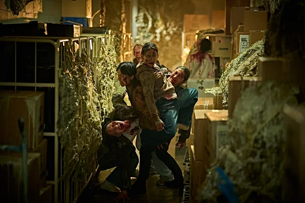 Scène du film Colony : des survivants ensanglantés dans un entrepôt.