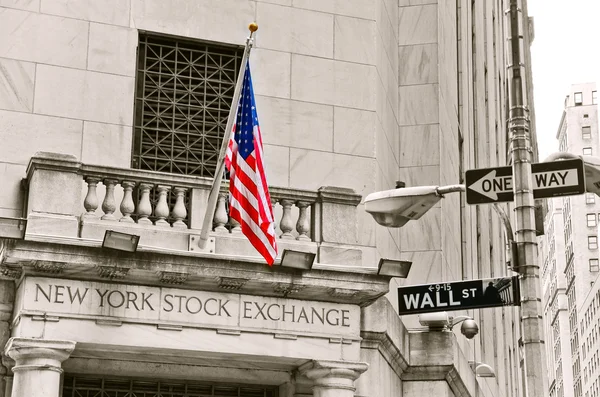 Le bâtiment de la Bourse de New York, avec le drapeau américain et les célèbres panneaux de Wall Street.