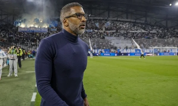Habib Beye sur le terrain d'un stade, évoquant les tensions au sein du vestiaire de l'OM.