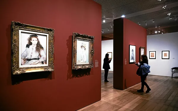 Une salle d'exposition du musée d'Orsay aux murs rouges, présentant des portraits du XIXe siècle.