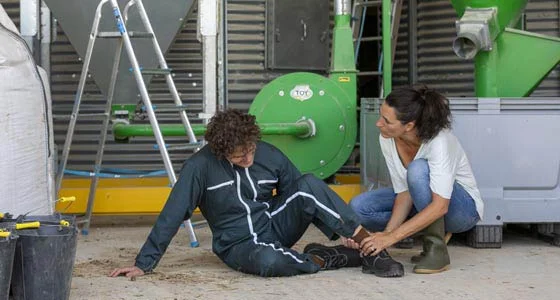 Scène d'assistance après un accident du travail dans un environnement industriel.