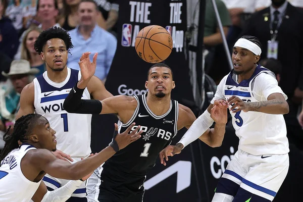 Victor Wembanyama au milieu des défenseurs des Timberwolves lors d'un match de playoffs NBA.