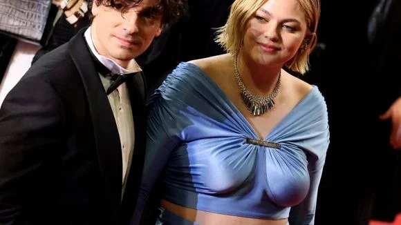 Louane et Florian Rossi en tenue de soirée, elle en robe bleue, lui en smoking.