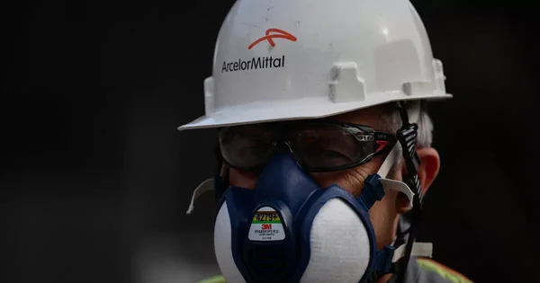 Un salarié d'ArcelorMittal équipé d'un masque respiratoire et d'un casque de sécurité.