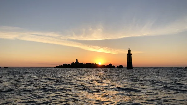 Phare du Finistère au coucher du soleil, symbole du littoral breton.