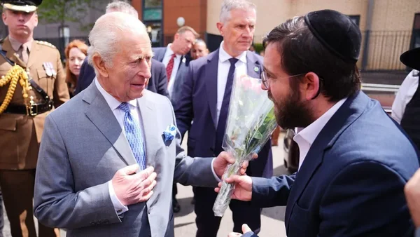 Le roi Charles III reçoit un bouquet de fleurs d'un membre de la communauté juive lors d'une visite à Golders Green.