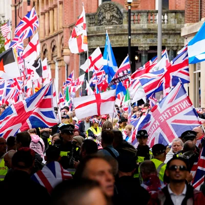 Manifestants d'extrême droite défilant dans une rue de Londres, encadrés par la police.
