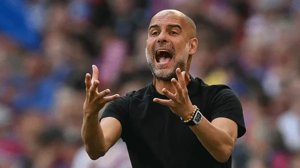 Pep Guardiola exprimant ses émotions de manière véhémente sur le bord du terrain.