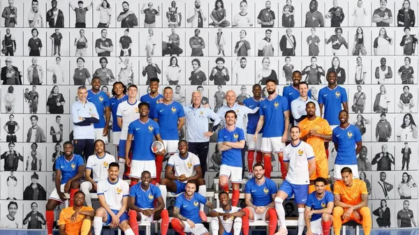 Les Bleus posent pour une photo artistique devant un mur de portraits au centre d'entraînement.