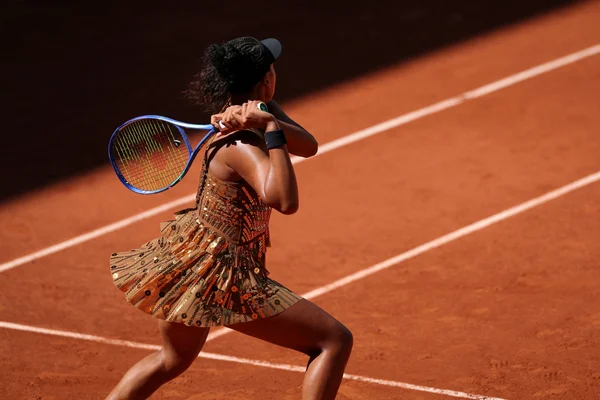 Naomi Osaka en robe à sequins sur le court Suzanne-Lenglen, en pleine action.