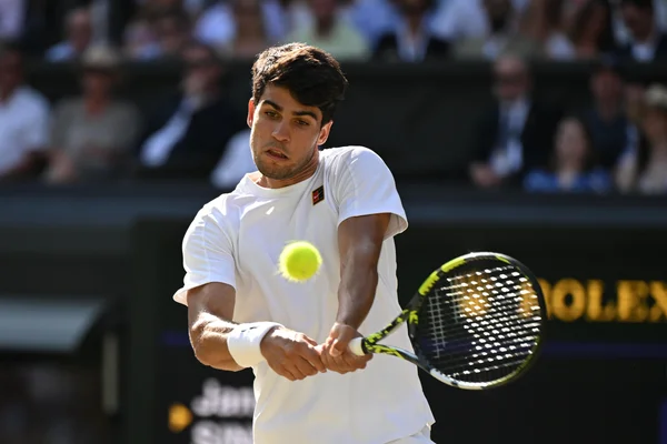 Carlos Alcaraz en action sur un court de tennis, frappant une balle.