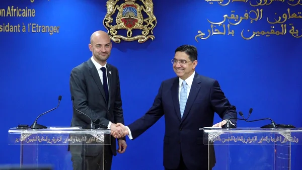 Nasser Bourita et Jean-Noël Barrot lors d'une rencontre officielle, derrière des pupitres sur fond bleu aux emblèmes dorés.