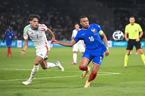 Un joueur français dribble sous la pression d'un défenseur italien lors d'un match France - Italie.