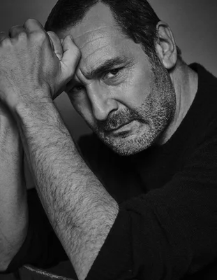 Gilles Lellouche en noir et blanc, la tête sur la main.