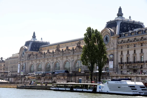 Le musée d'Orsay vu depuis la Seine, avec un bateau-mouche amarré au premier plan.