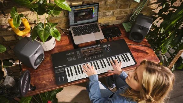 Une musicienne utilisant un clavier Native Instruments Komplete Kontrol S49 dans un studio.