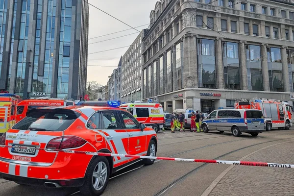 Véhicules de secours des pompiers et de la police à Leipzig, secouristes en tenue haute visibilité.