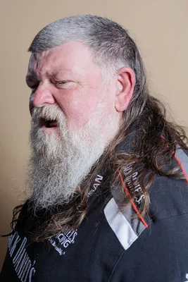 Participant au Mulletfest 2022 arborant une longue barbe et une coupe mulet grise.
