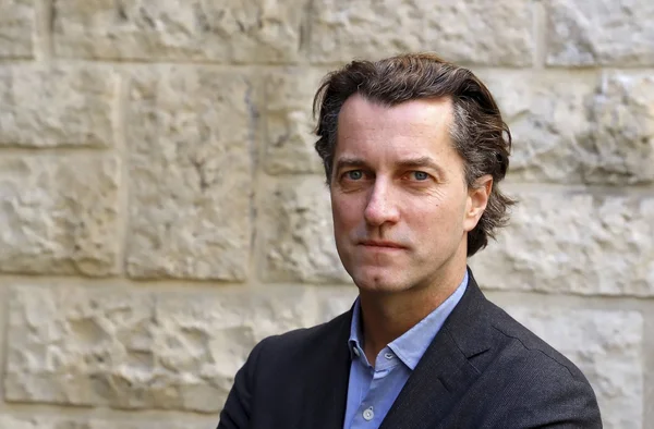 Dominique Boutonnat, patron du CNC, devant un mur en pierre.